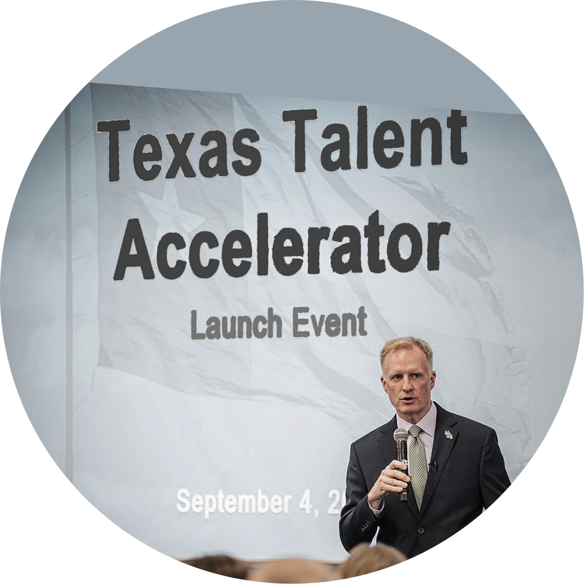 UNT presidents holding a microphone at the Texas Talent Accelerator Launch Event, with the event title projected behind him.