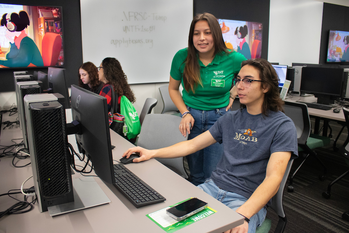 student working with staff on computer